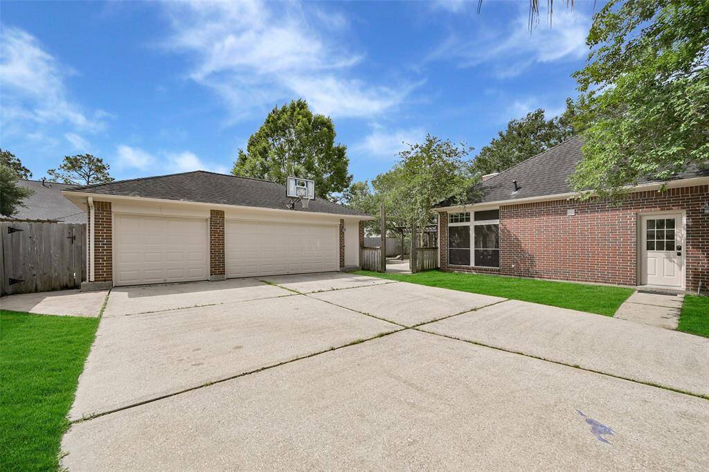 Extended driveway leads to a gated motor court and detached 3-car garage with a large parking pad, offering added privacy and secure parking—an ideal setup for families or entertaining guests.