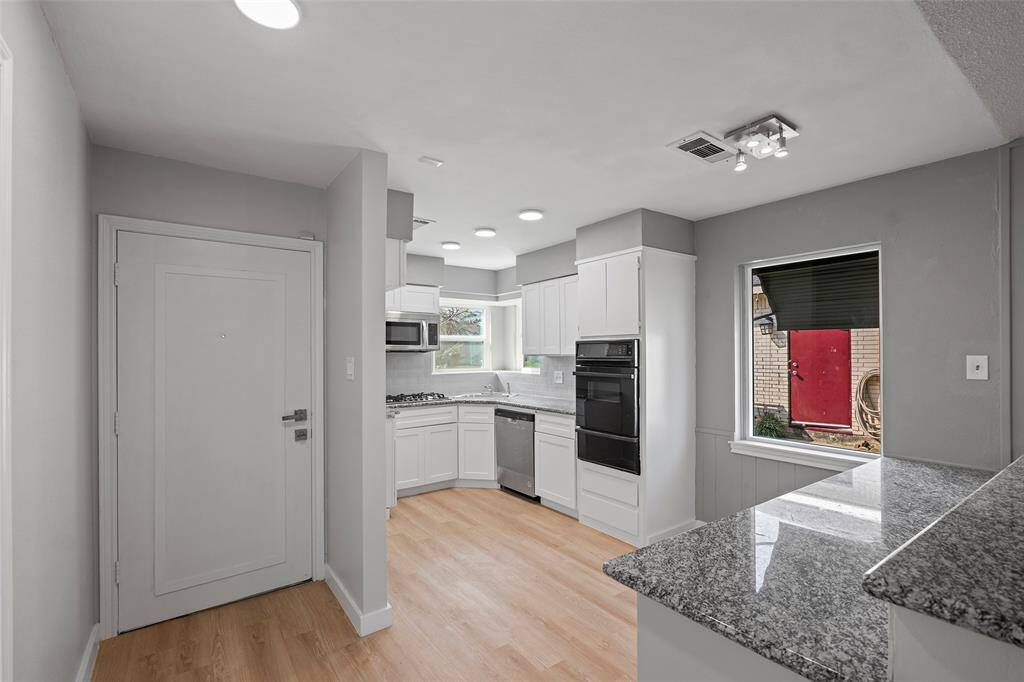 Kitchen with granite countertops, and tile backsplash.