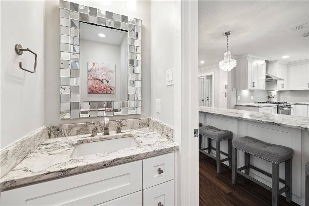 A nearby powder room with a custom dolomite topped vanity adds convenience for guests.