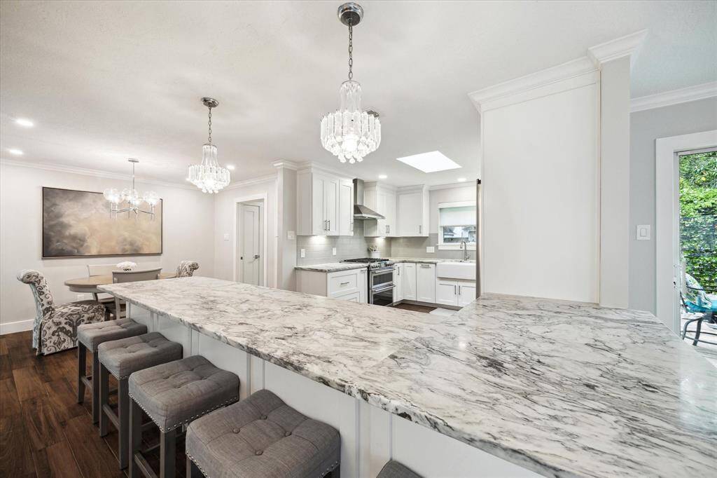 The kitchen features gorgeous dolomite countertops and soft-close, full-extension white cabinetry set against a chic subway-tile backsplash.