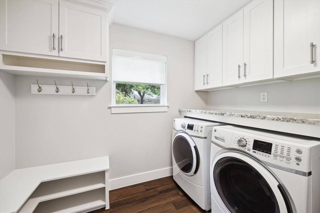 The utility room is equipped with a built-in bench and cabinet space as well as a coat closet, providing excellent storage and organization. It leads to the attached two car garage.