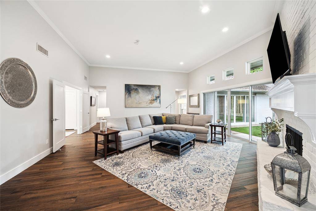 Bright and open, this living room features recessed lighting and sliding glass doors that seamlessly extend the space to the covered patio and backyard.