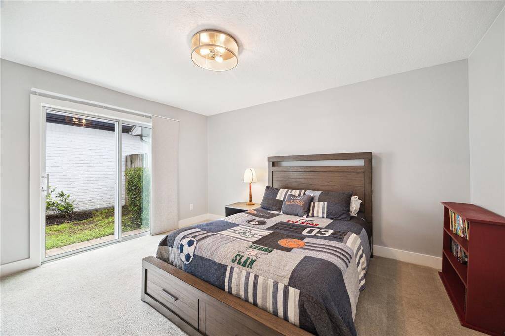 This bright and spacious secondary bedroom features sliding door access to the backyard.