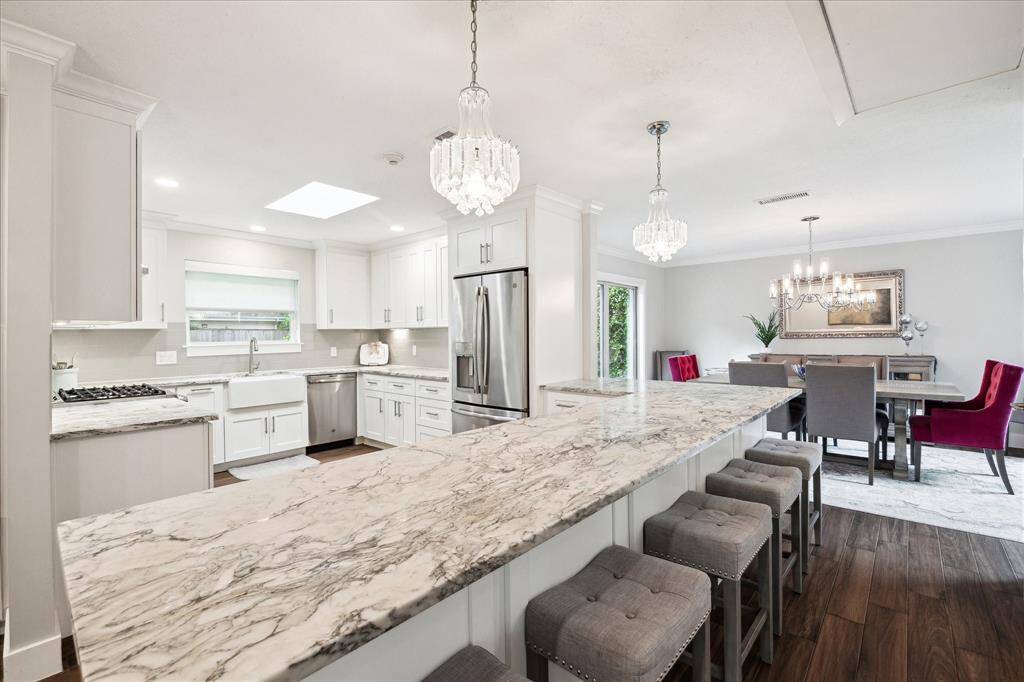 The open kitchen offers plenty of space for pull-up seating at the expansive peninsula topped with dramatic dolomite, making casual meals and entertaining a breeze. Generous counter space provides easy room for prep or dining.
