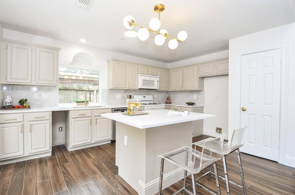 Updated kitchen with new lighting and New Quartz Counters with new modern backsplash.
