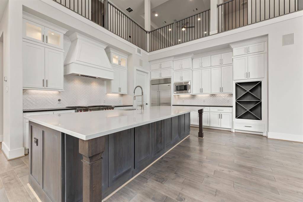 Spacious and elegant kitchen featuring high-end appliances, a large island with a sleek countertop, and ample cabinet space for all your culinary needs.