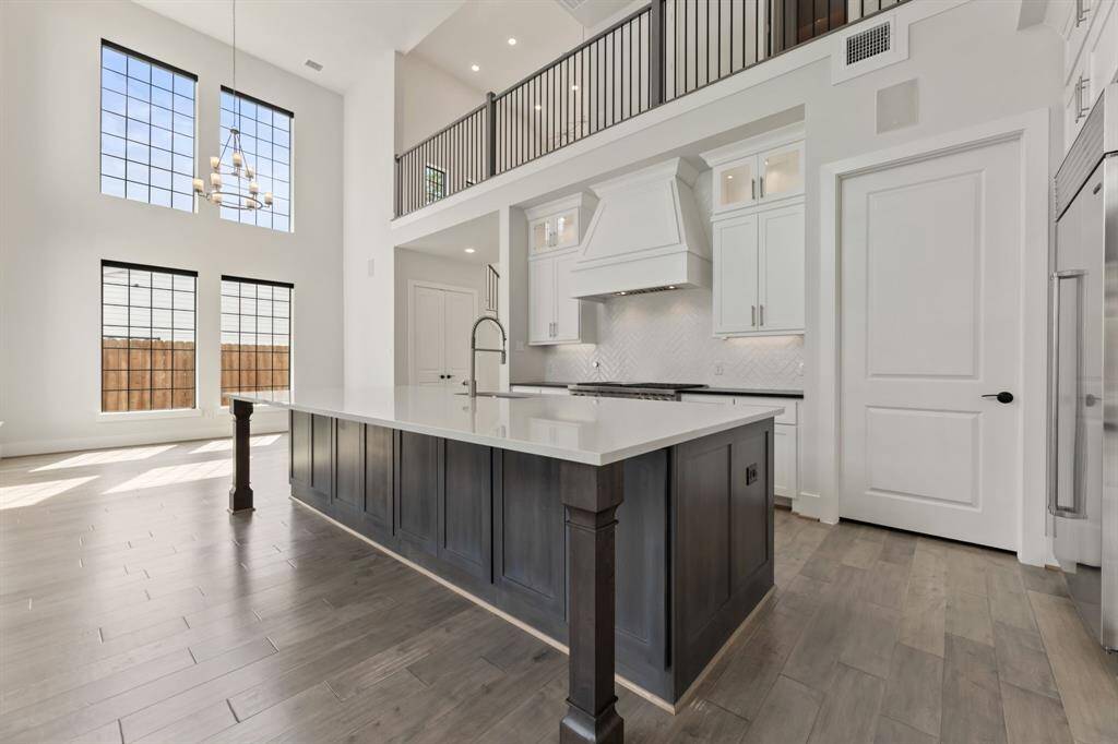 Spacious and elegant kitchen featuring high-end appliances, a large island with a sleek countertop, and ample cabinet space for all your culinary needs.