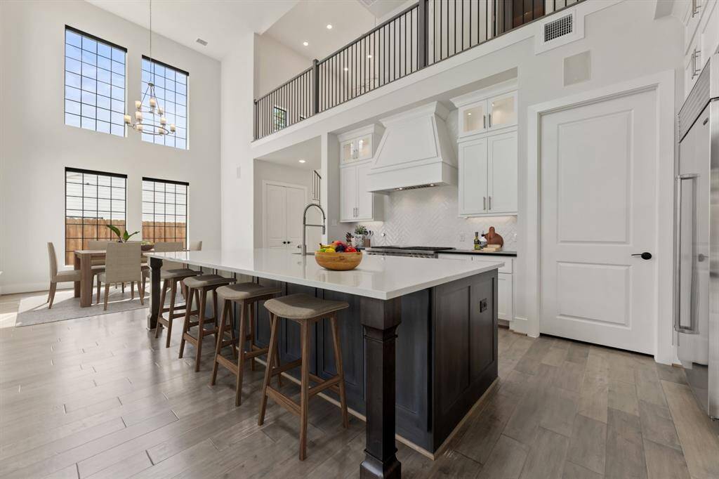 Spacious and elegant kitchen featuring high-end appliances, a large island with a sleek countertop, and ample cabinet space for all your culinary needs.