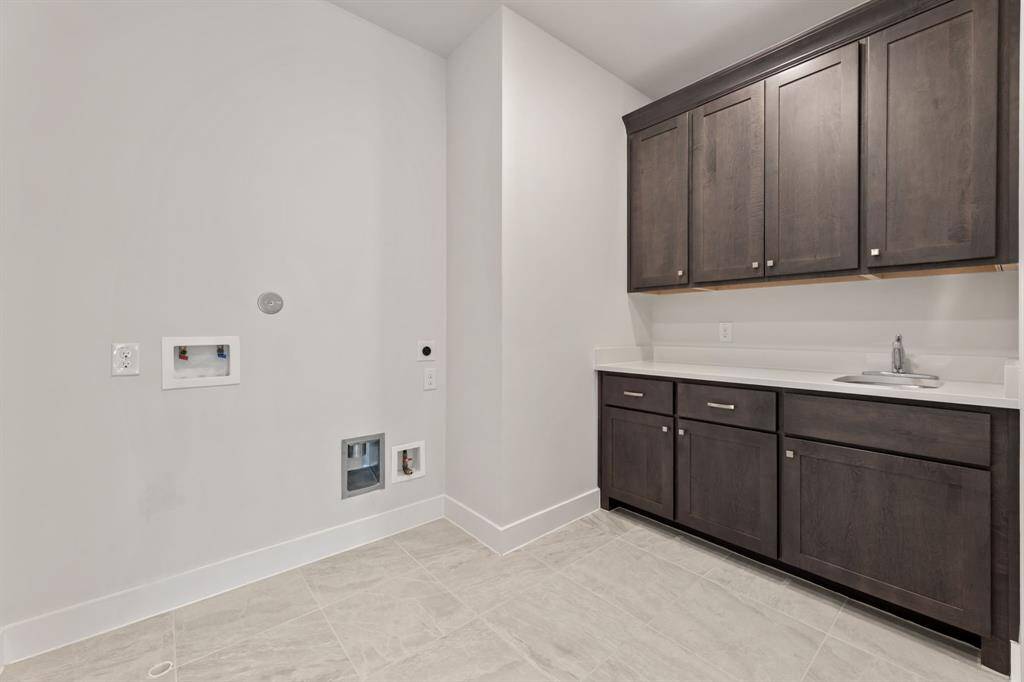 Dedicated laundry room featuring ample cabinetry, sleek countertops, and convenient washer/dryer hookups—perfect for all your laundry needs.