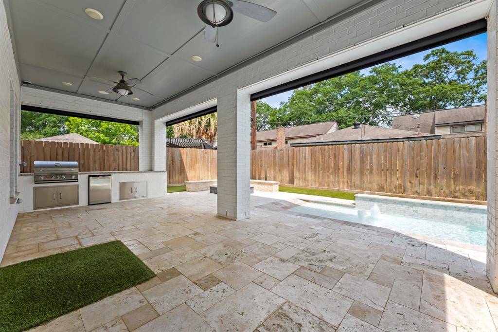 Experience outdoor dining at its finest with this sleek kitchen, featuring a stainless steel grill, mini-fridge, and ample counter space, perfect for entertaining.