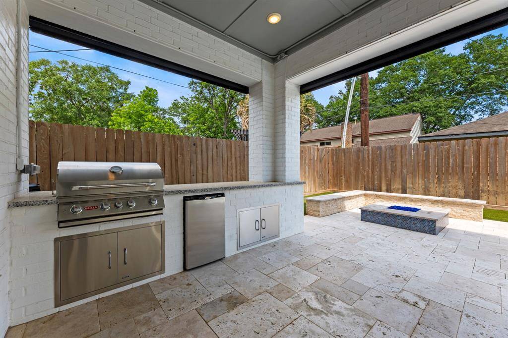 Experience outdoor dining at its finest with this sleek kitchen, featuring a stainless steel grill, mini-fridge, and ample counter space, perfect for entertaining.