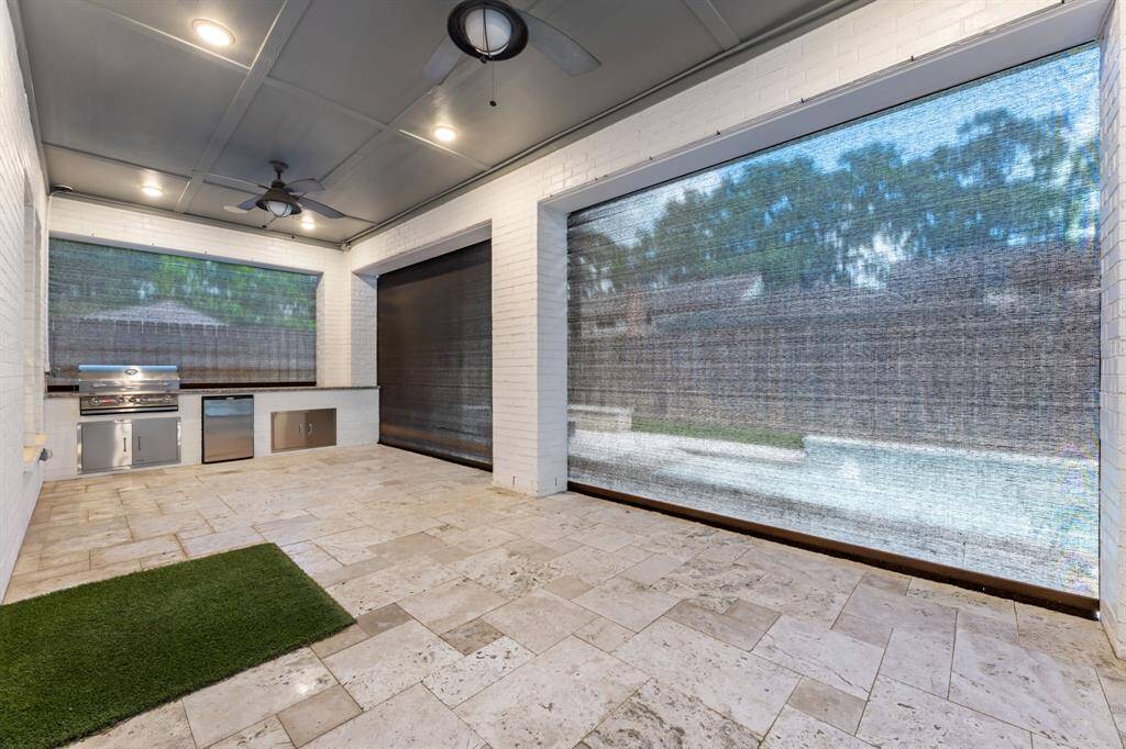 Experience outdoor dining at its finest with this sleek kitchen, featuring a stainless steel grill, mini-fridge, and ample counter space, perfect for entertaining.