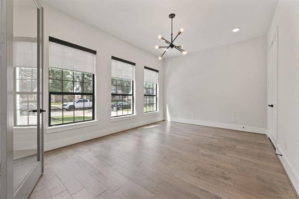 Bright and inviting home office with large windows, sleek flooring, and modern lighting—perfect for productivity.