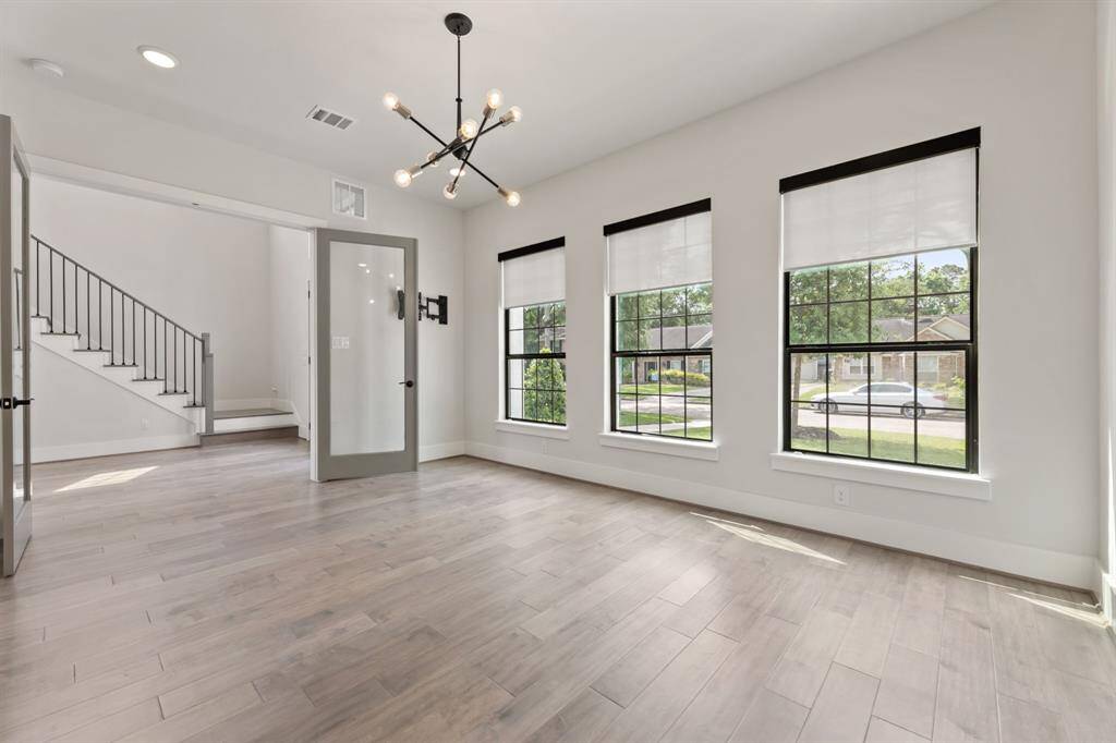 Bright and inviting home office with large windows, sleek flooring, and modern lighting—perfect for productivity.