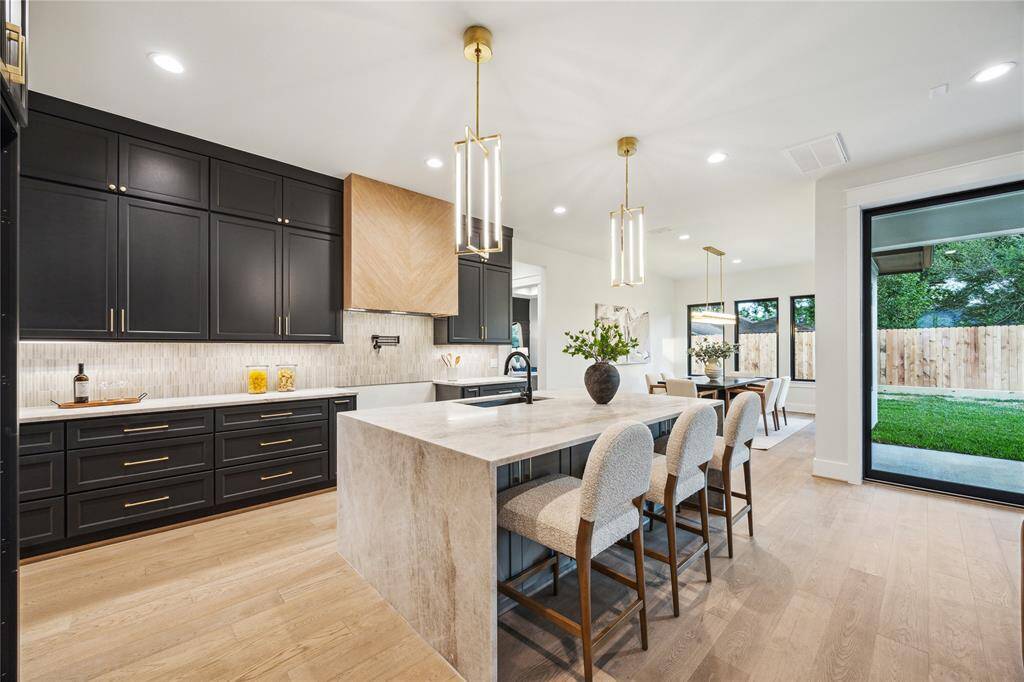 The kitchen features Taj Mahal quartzite countertops including waterfall island.