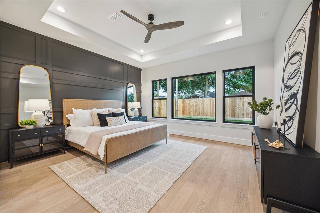 The primary bedroom has a trayed ceiling and decorative accent wall.