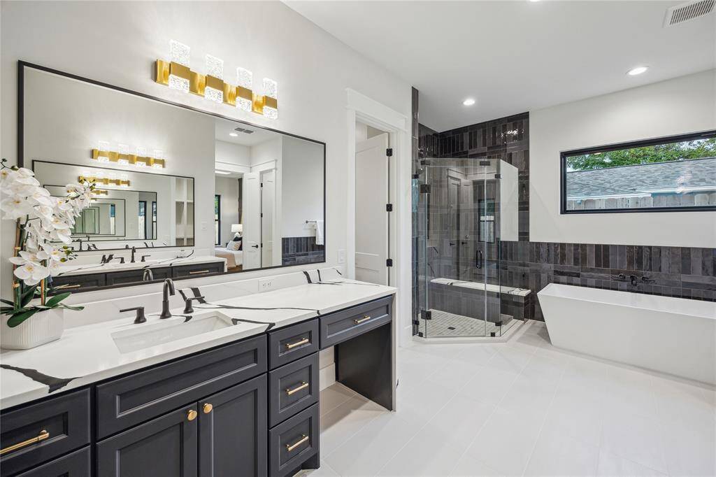 The primary bathroom has separate his and her vanities with gorgeous waterfall quartz end panels.