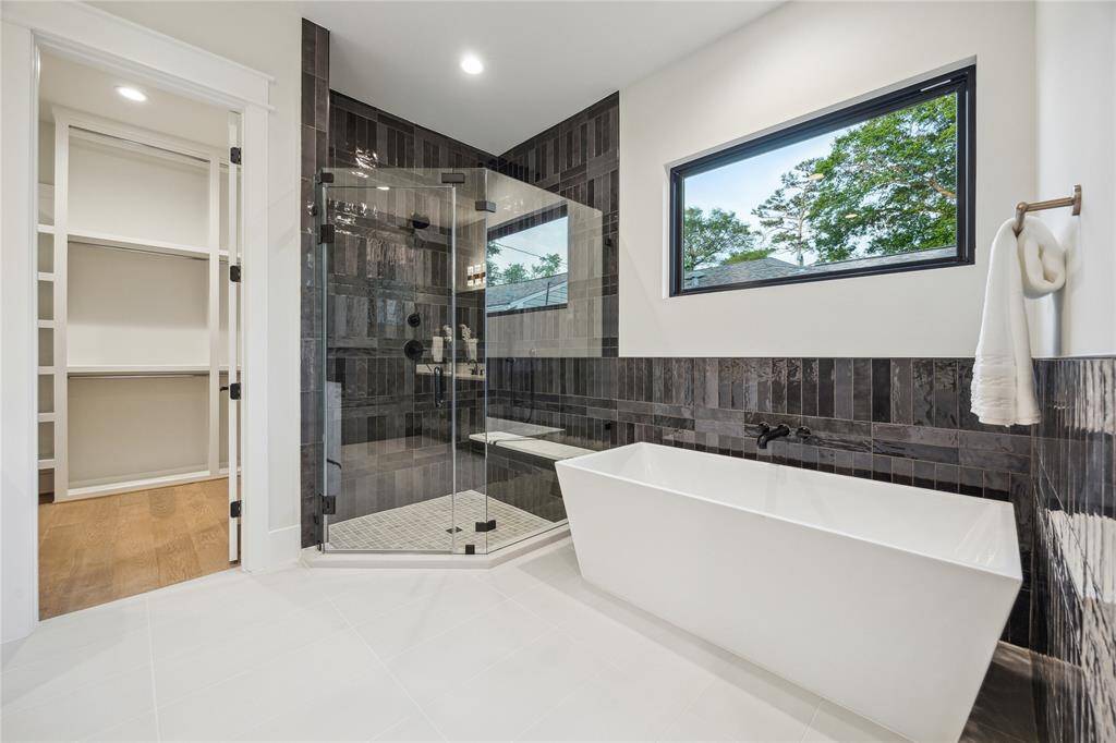 Oversized shower with creative tile work and freestanding tub.