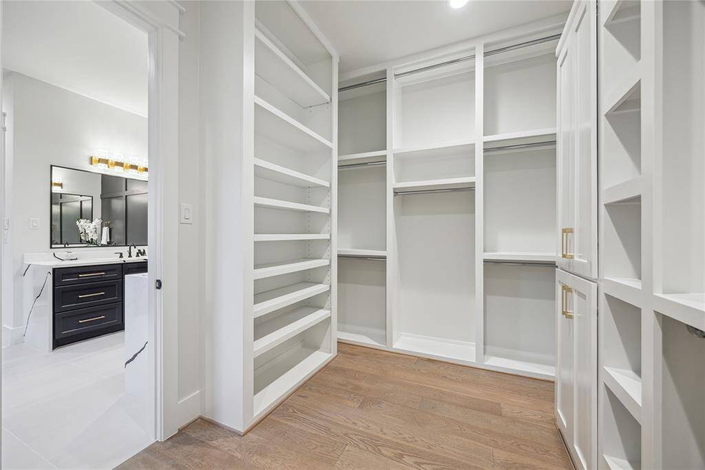 The primary closet has custom floor-to-ceiling shelving and hanging space. There's even a passthrough to the laundry room!