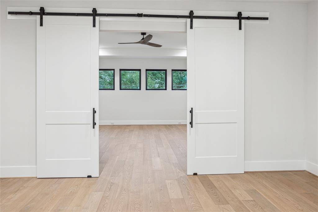The game room is accessed through barn doors off the loft at the top of the stairs.