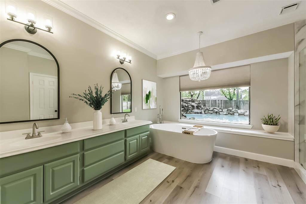 This spacious primary bedroom offers a serene retreat with soft neutral tones and elegant crown molding. The room features large windows that provide natural light and a view of the backyard. A ceiling fan adds comfort, while the ensuite bath is conveniently accessed through a private entry. With plenty of room for a king-sized bed and additional furnishings, this space is both relaxing and functional. Virtually Staged