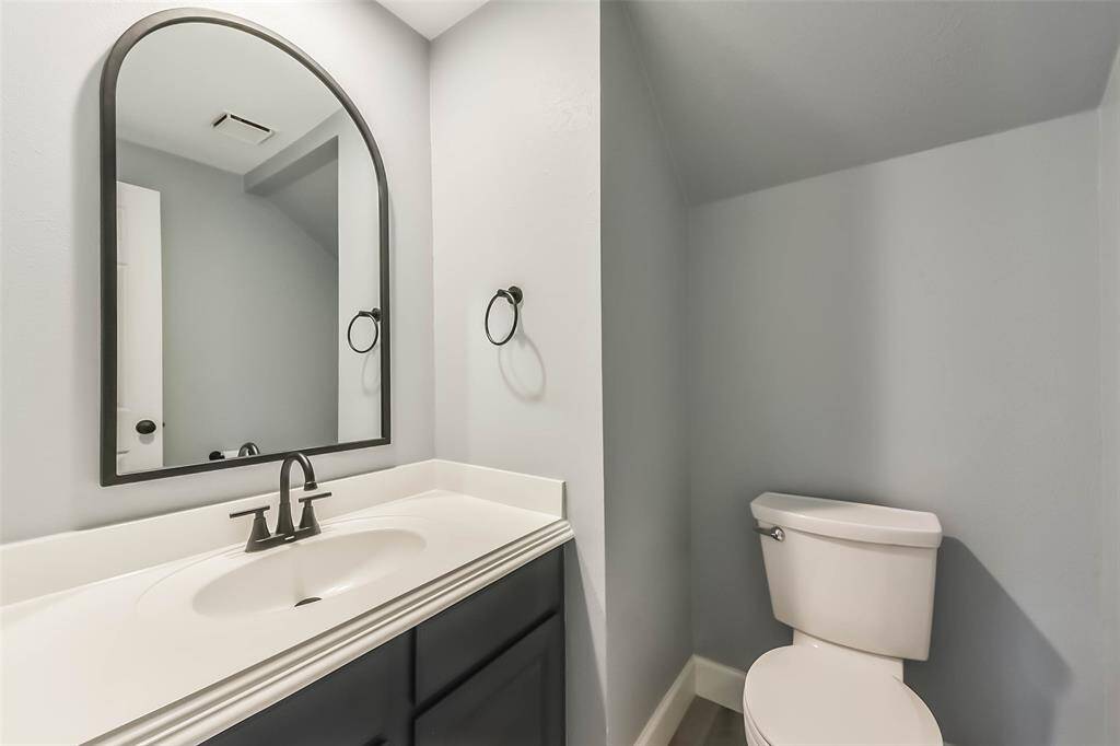 This stylish half bath is conveniently located for guests and features modern fixtures and a sleek vanity.