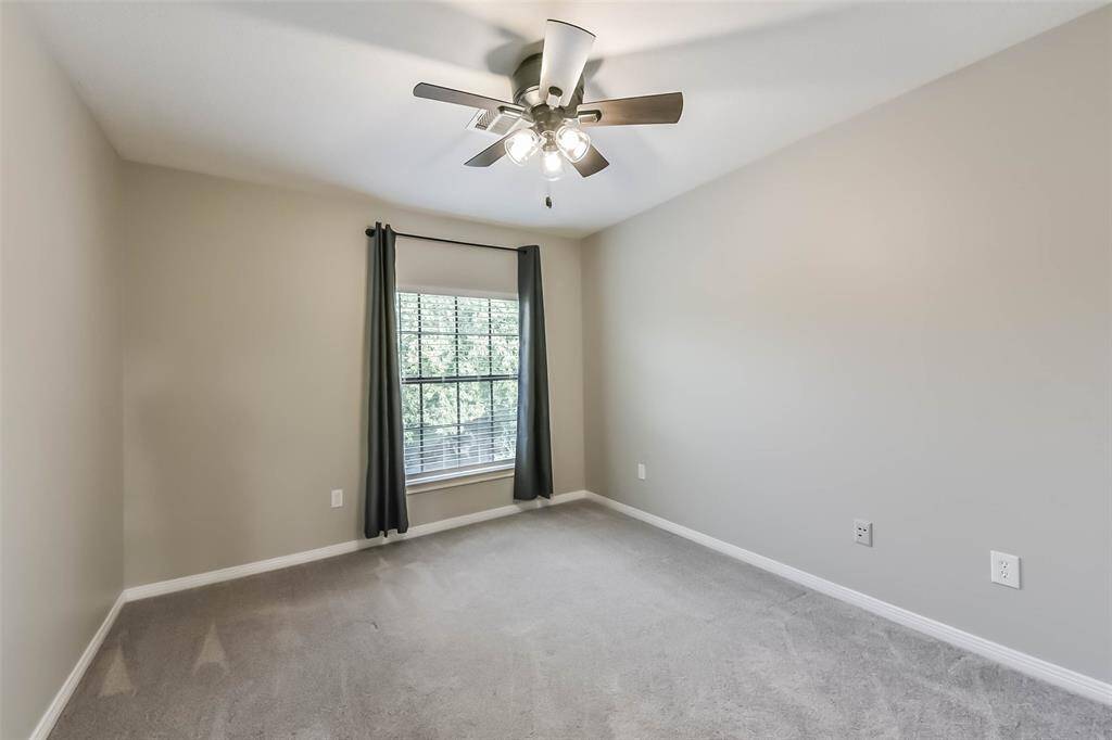 This spacious secondary bedroom located on the second floor offers comfort and versatility. The room features a large window that lets in plenty of natural light. A modern ceiling fan adds both style and functionality. With ample space and a cozy atmosphere, it's a perfect retreat within the home.