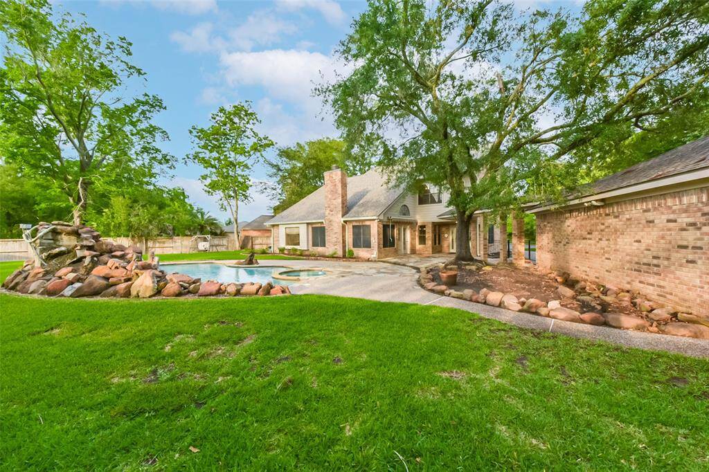 This beautifully landscaped backyard features a spacious lawn surrounded by mature trees, offering both privacy and a peaceful atmosphere. Enjoy a picturesque view. This outdoor space is perfect for any lifestyle. It’s the ideal setting to enjoy the outdoors right at home.