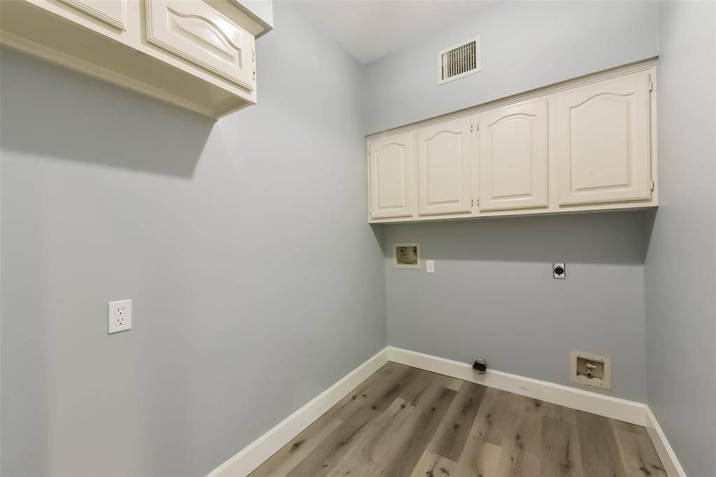 The oversized laundry room offers exceptional functionality with built-in cabinetry. With room to move and work comfortably, this laundry area blends convenience with thoughtful design.