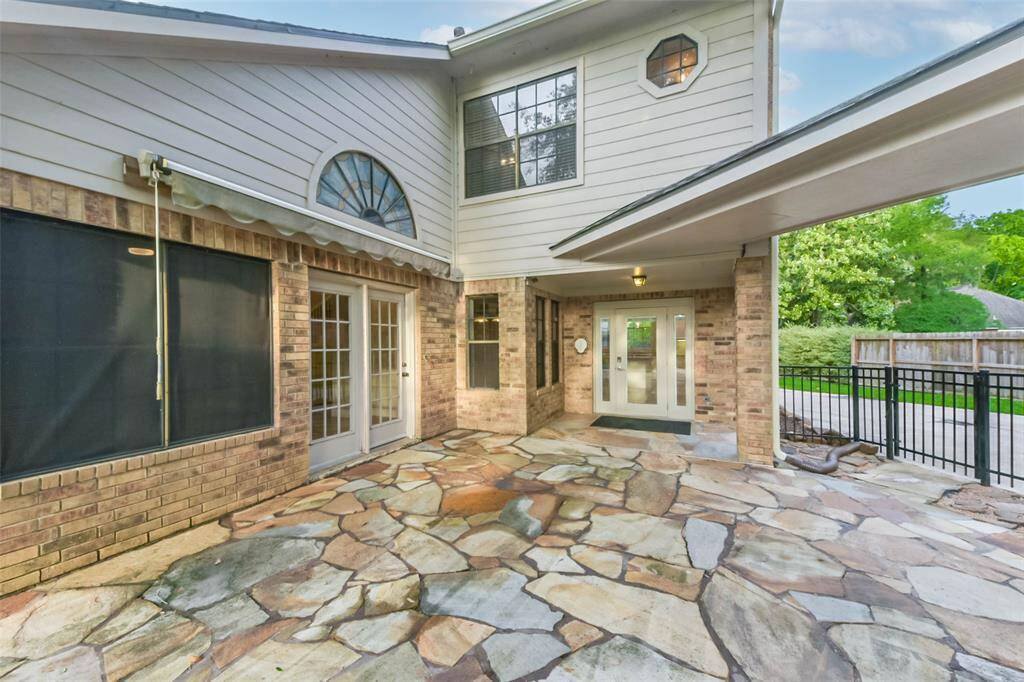 This spacious back patio offers the perfect spot for outdoor dining and entertaining. Conveniently accessible from both the breakfast area and the living room, it provides a seamless indoor-outdoor flow. The flagstone tile adds rustic charm, while the covered section offers shade and comfort. It's an ideal extension of your living space for relaxing or hosting guests.