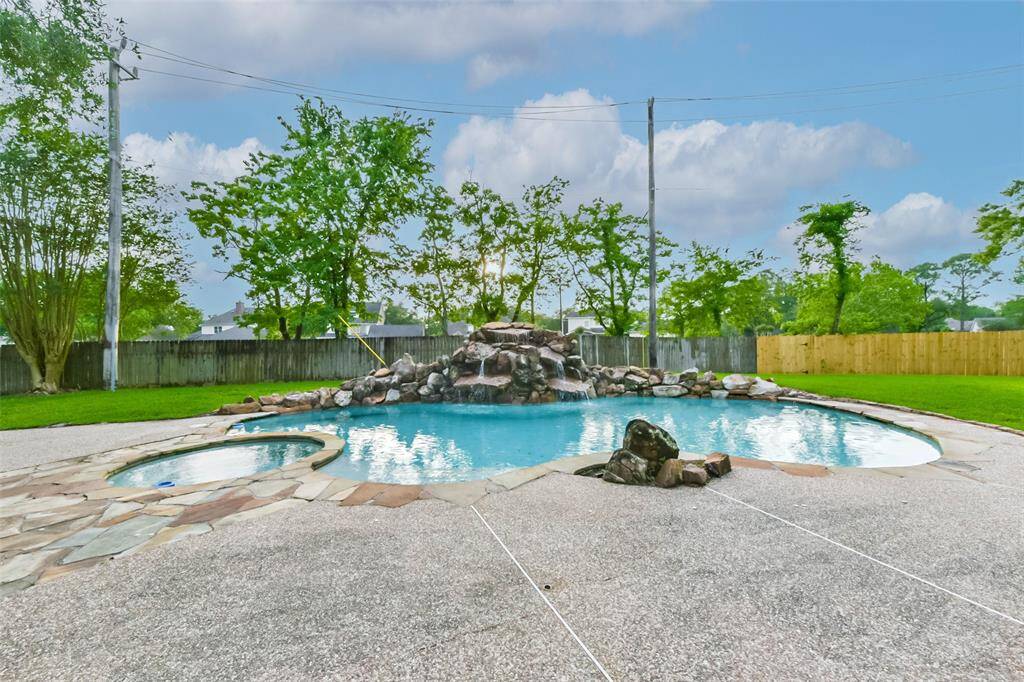 Enjoy your own backyard oasis with this stunning pool featuring a rock waterfall and attached spa. Surrounded by lush landscaping and a spacious patio, it's perfect for both relaxing and entertaining. The pool/spa area offers plenty of room for lounge chairs, outdoor dining, and summer fun. A true highlight of the home, this space brings resort-style living to your doorstep.