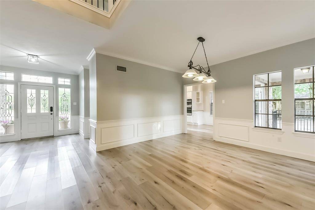 This elegant dining room is situated perfectly between the living room and kitchen, offering a central space ideal for entertaining and everyday meals. Stylish wainscoting and a modern light fixture add a touch of sophistication to the room. Its open layout enhances the flow of the home, making it both functional and inviting.