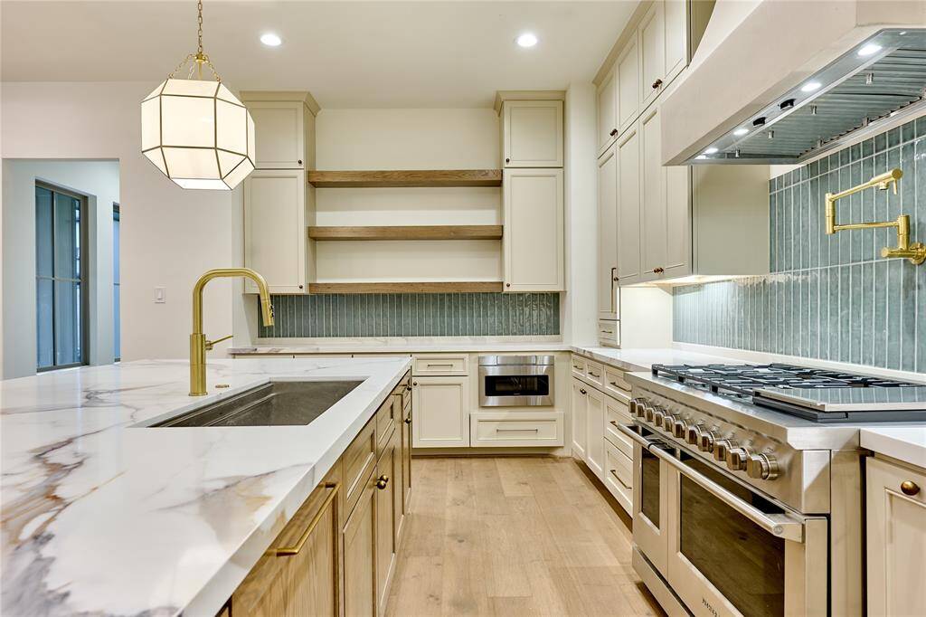 Two-toned cabinetry paired with subtle sage tone backsplash.