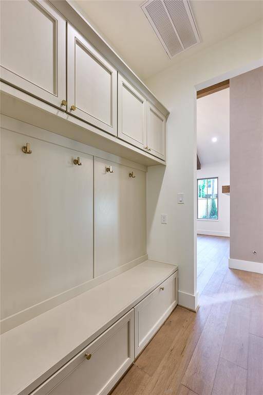 Well-appointed mudroom with built-in storage cabinets, hooks for hanging items, and a bench for convenience.