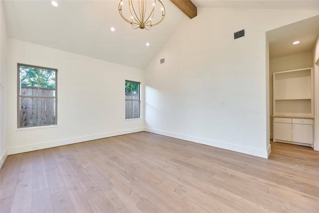 Bright and inviting primary suite featuring high ceilings with exposed wooden beams.