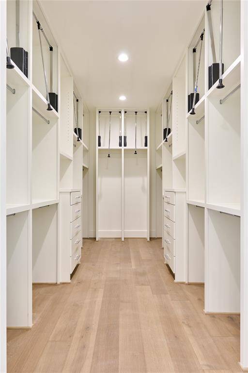 Spacious walk-in primary closet offering ample storage.