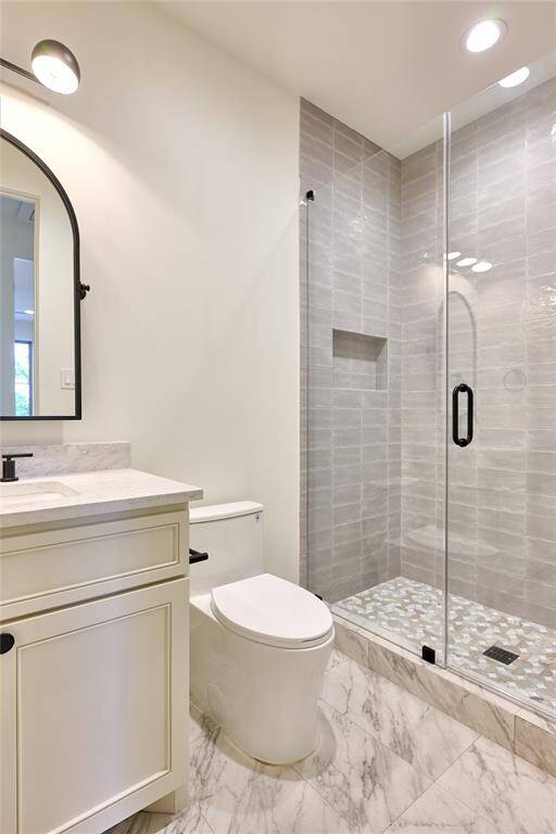 Offering a sleek walk-in shower adorned with elegant Maiolica Tender Grey wall tile and a luxurious marble mosaic floor.