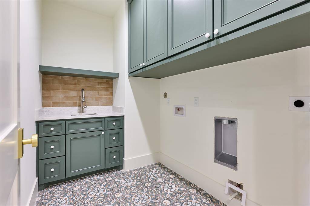 The utility room showcases built-in cabinetry in a soft green hue, offering both style and functionality.
