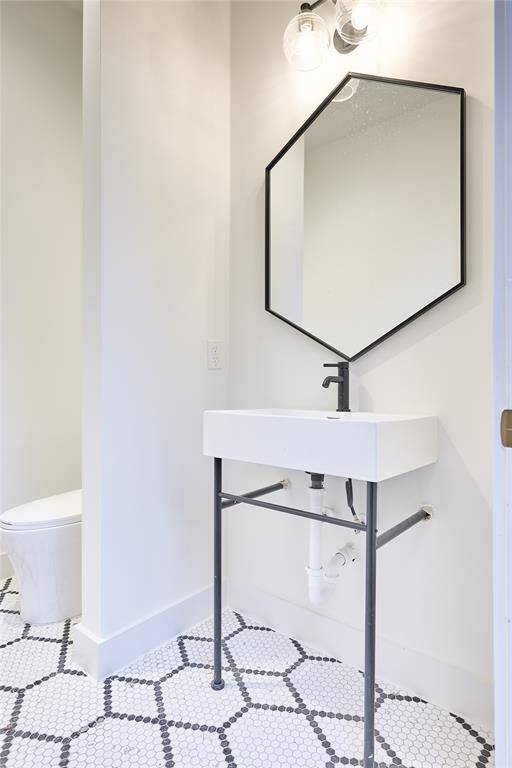 The conveniently located pool bathroom offers easy outdoor access and featuring a Hive pattern matte porcelain mosaic tile floor.
