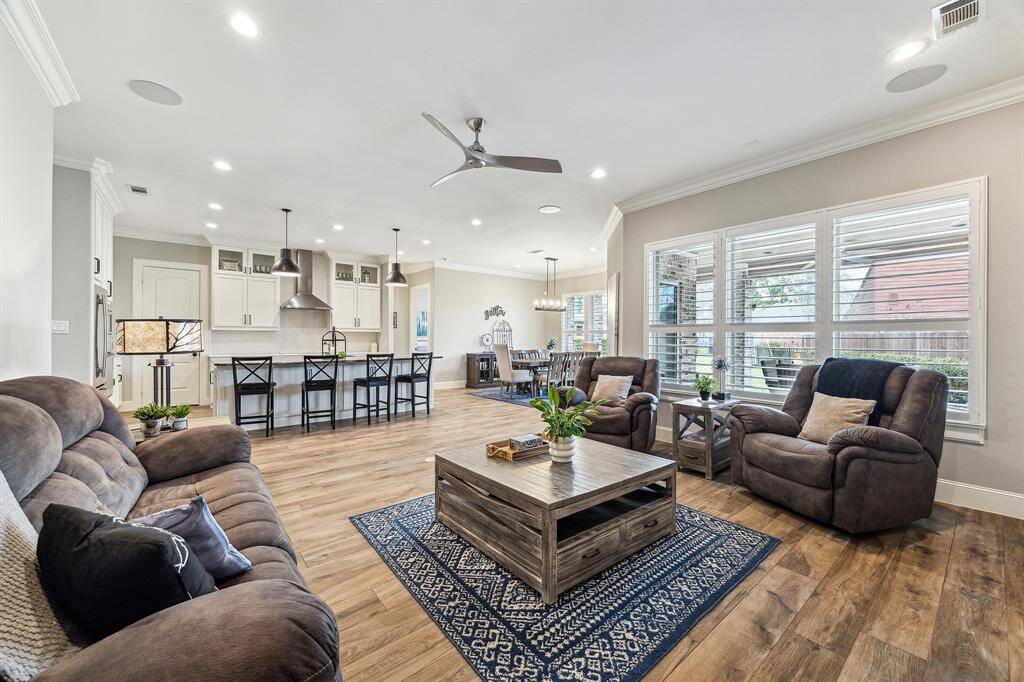 An inviting living space featuring tile flooring, white plantation shutters, and an abundance of windows that flood the room with natural light.