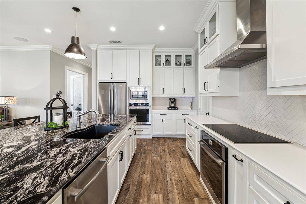 Stylish herringbone-patterned backsplash adds texture and sophistication. Kitchen also has a large pantry.