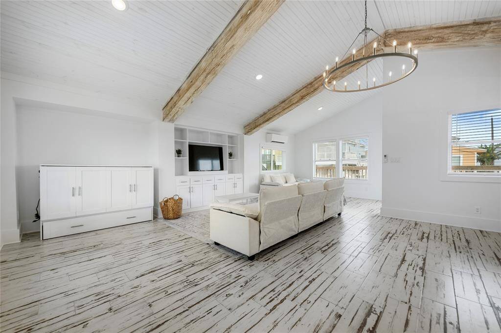 Walked thru the glass sliding door, inside the cottage is the open-concept living space featuring bright, lots of natural light, and full of coastal charm.