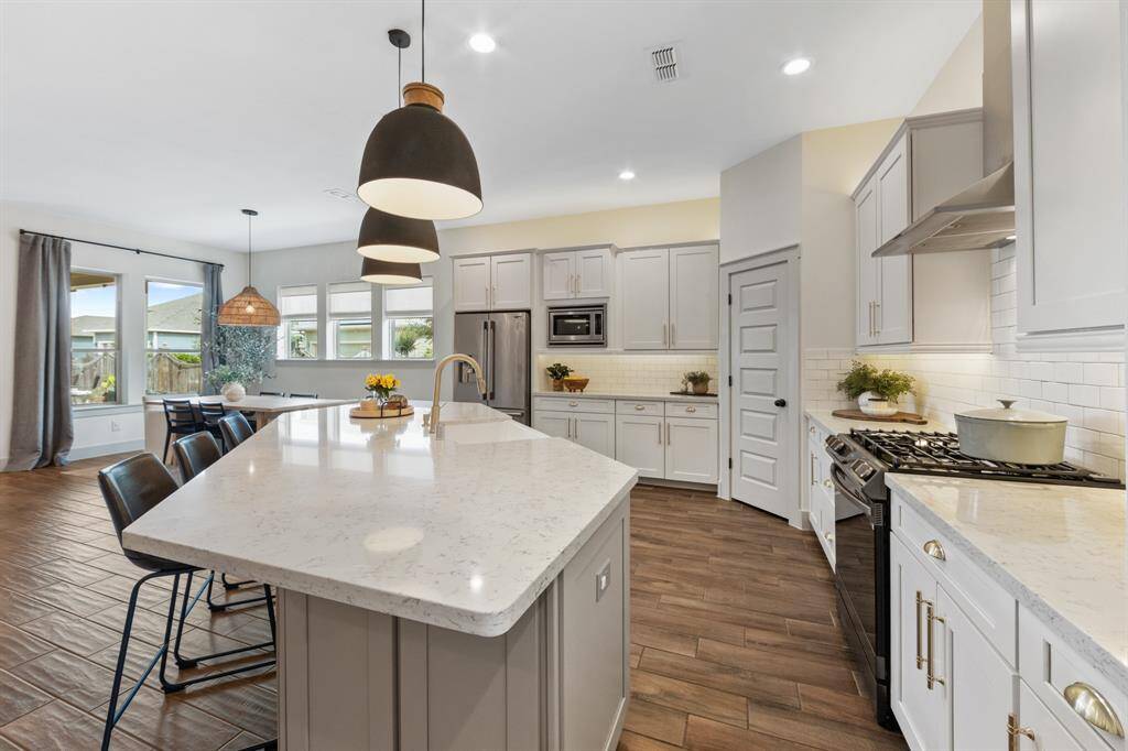 The kitchen features elegant white granite countertops that add a bright, spacious feel and timeless appeal, paired with a classic white brick-style backsplash for a clean, modern look.