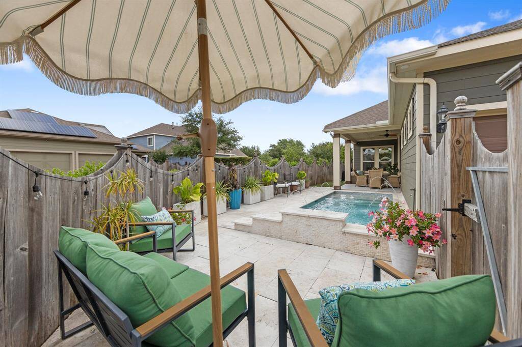 This patio is a serene escape beside the heated pool, designed as a tranquil oasis with greenery and relaxing ambiance.