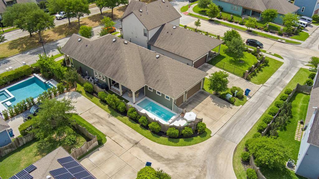 Crisp roofline and manicured landscaping frame the heated pool and outdoor living spaces.