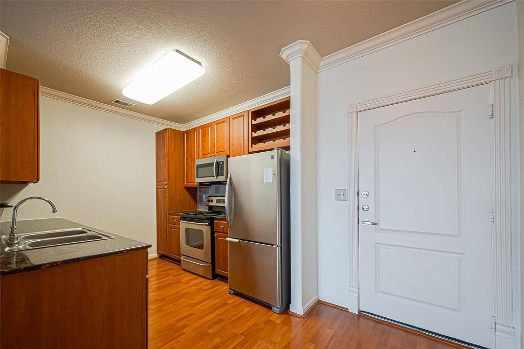Updated kitchen with storage cabinets and stainless steel appliances.