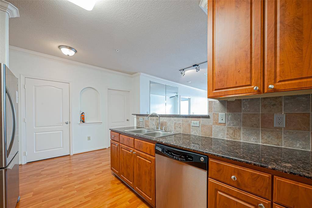 Spacious cooking and stainless steel appliances with an open view of the living room to the balcony.