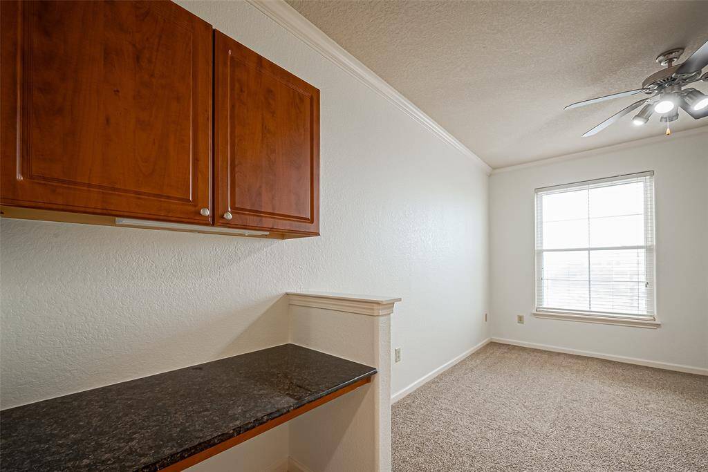 This room features a cozy carpeted area  Ideal for a home office or study space.