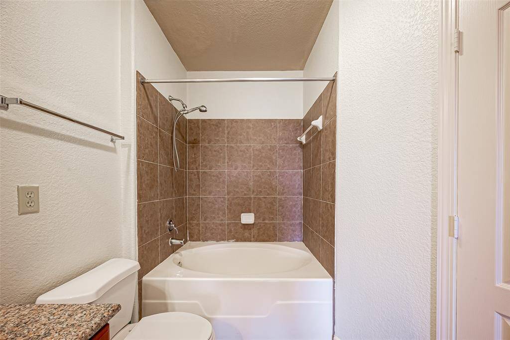 This is a cozy bathroom featuring a tub-shower combo.
