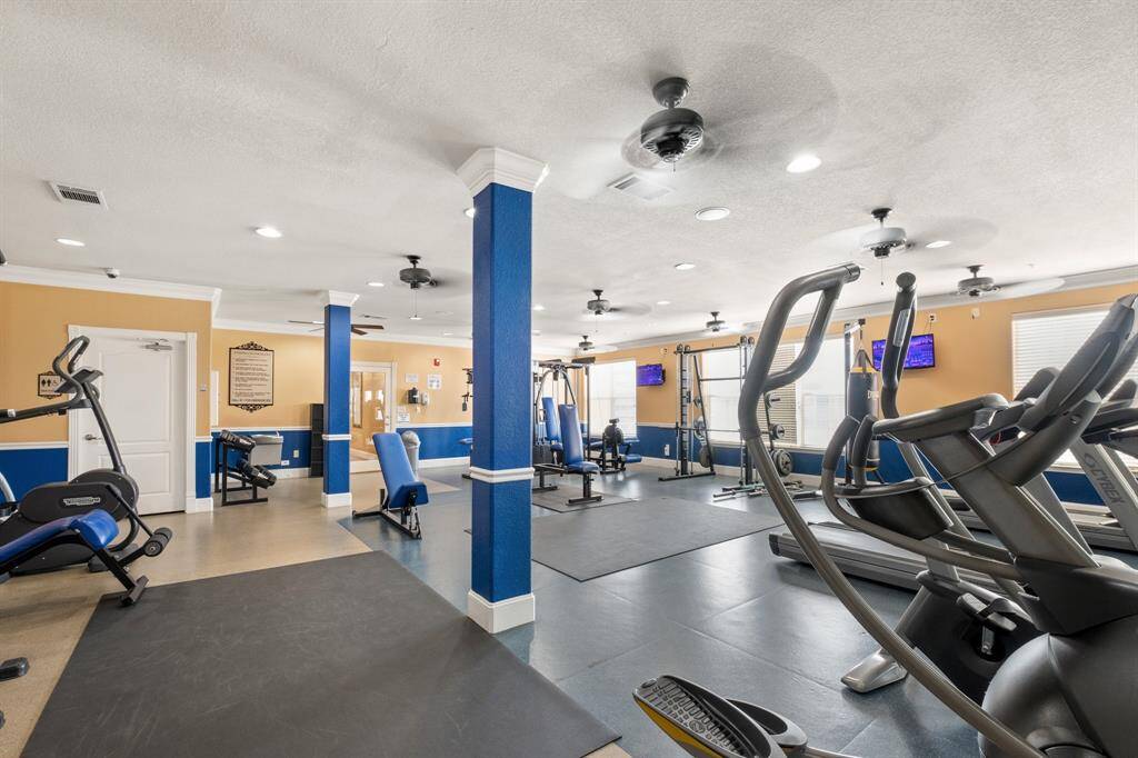 This is a spacious, well-equipped fitness center featuring various cardio and strength training machines.